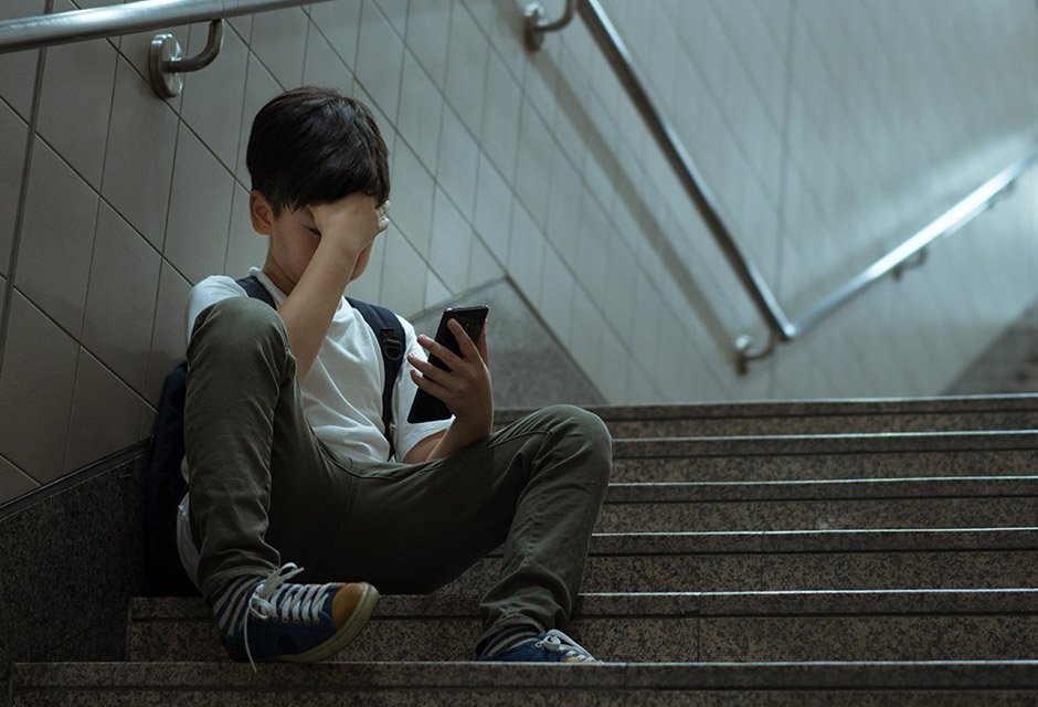 Pojke med mobil Pojke tittar på en mobiltelefon